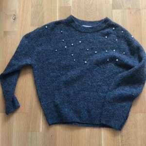 Skickad tröja  - Grå stickad tröja med pärlor. Ifrån H&M i storlek 134/140. Några pärlor har lossnat då det sticker ut några trådar.