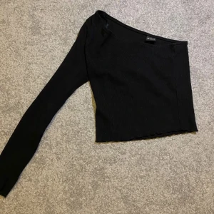 Svart tröja - Helt ny oanvänd tröja med ”en ärm” Ribbad och superskönt och stretchigt material!