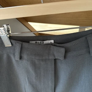 Grå kostymbyxor från NA-KD - Gråa jättefina kostymbyxor med slits från NAKD, endast använda ett fåtal gånger. Strl 36