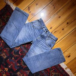 Ljusblå Jack & Jones jeans med coola detaljer😍 Innerbenslängd: 90cm  Dom är insydda i midjan!