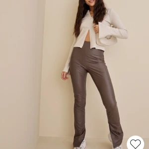 Byxor  - Säljer dessa bruna skinnbyxor från Nelly i storlek XS. Använd 1 gång. Byxorna sitter tajt men materialet är stretchigt, de har även slits på insidan. Ordinarie pris: 549kr men säljer dem för 300kr