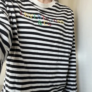 Tröja - Långärmad tröja från Levis. Svart och vit randig med text i olika färger på loggan. Mycket fint skick och mjukt material. Köpte för 499.