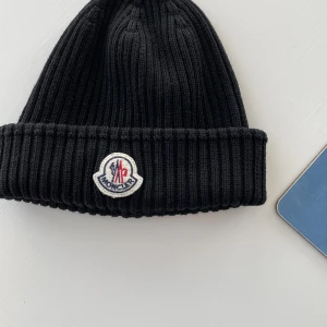 Moncler mössa - Moncler mössa som är i väldigt bra skick. Är inget fan av mässar därav säljer jag den. Mössan är mörkblå.