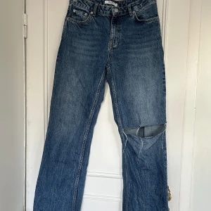 Blåa jeans med hål  - Säljer dessa blåa jeans med hål. Jeansen är i bra bra skick. Det är en rak modell med medelhög midja. 