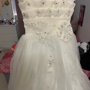 Fest klänning - Vit lång festklänning för barn. Har använts flera gånger, ser ut som brudens klänning och är väldigt fin.