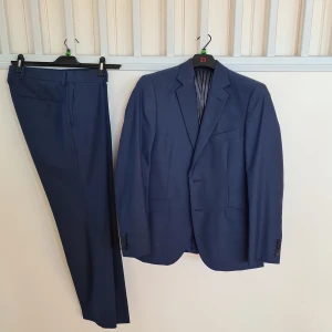 Kostym slim fit - Marinblå slimfit kostym-set i nyskick, använts vid ett tillfälle. Kavajen är strl 50, byxorna är strl 32x32.