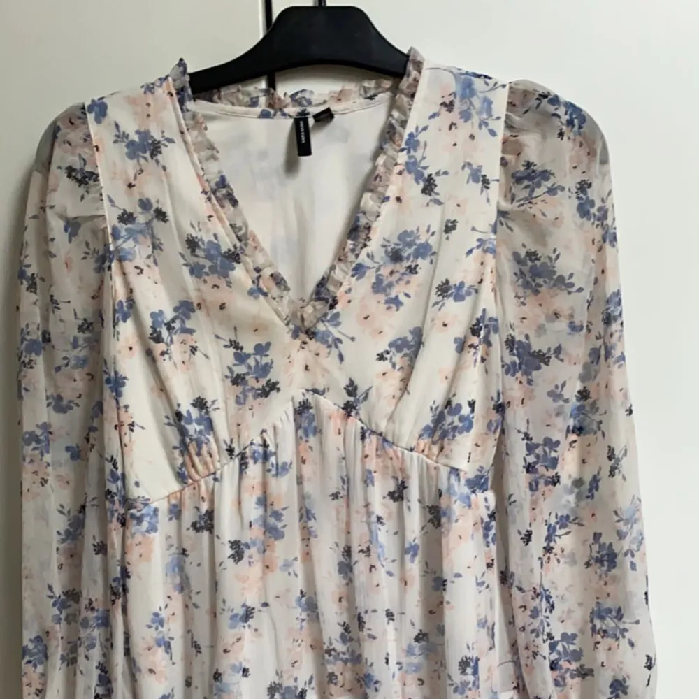 En blommig klänning från vero moda perfekt för sommaren. Den har långa ärmar som är tunna. Slutar strax ovanför knäna. Storlek XS. Blå och rosa blommar . Klänningar.
