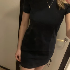 Klänning - Navyblå klänning med snören på sidorna, strl S men passar M också