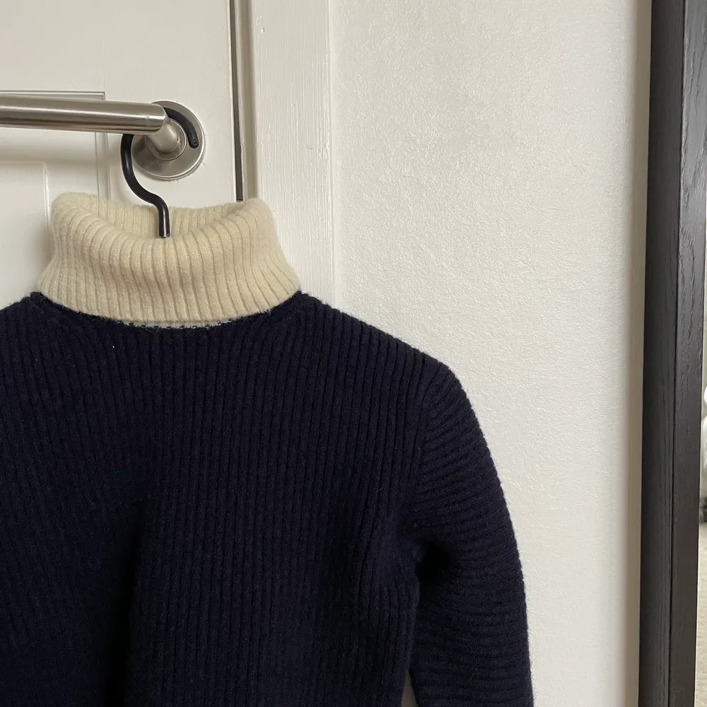 Marinblå stickad tröja från acne studios med vit polokrage. Lite kortare i modellen, speciellt fin till lågmidjade byxor💙. Neuleet.