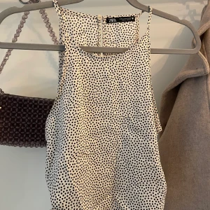 Sommrig topp strl M - Sötaste prickiga toppen från Zara. Champagnefärgad med svarta prickar. Storlek M men passar även XS-S då den är lite liten i storlek. Man kan knyta upp den i sidorna för olika passform. Mycket bra skick! 👌🏻💛 Finns inte längre i butik eller online.