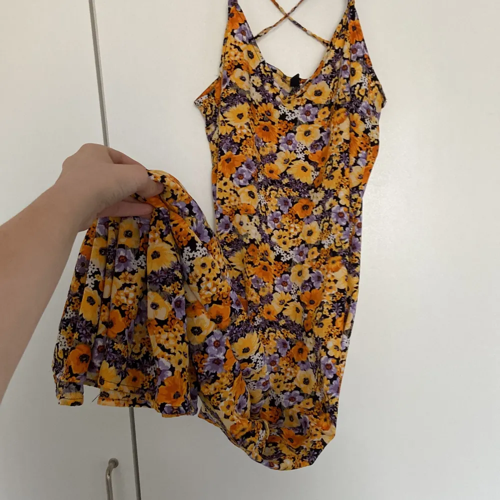 Orsnge lila gul blommig sommar klänning från hm som har korsad rygg aldrig använd för att den är för lång för mig jag är 165 ca . Mekot.