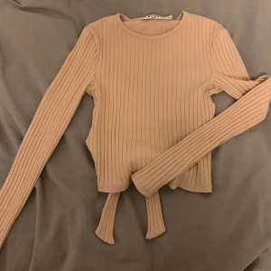 Topp från NAKD  - Jättefin långärmad topp från NAKD med knuytnibg i ryggen. Fortfarande i bra skick och inga slitage. Ingen budgivning och köparen står för frakten💕💕