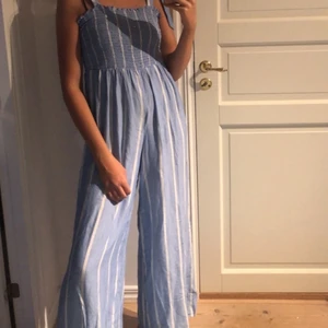 Jumpsuit  - Blå/vit randig. När jag körde den i maskinen skrynkla den ihop sig, vet inte om det går att lösa men tror det! Köparen står för frakten.