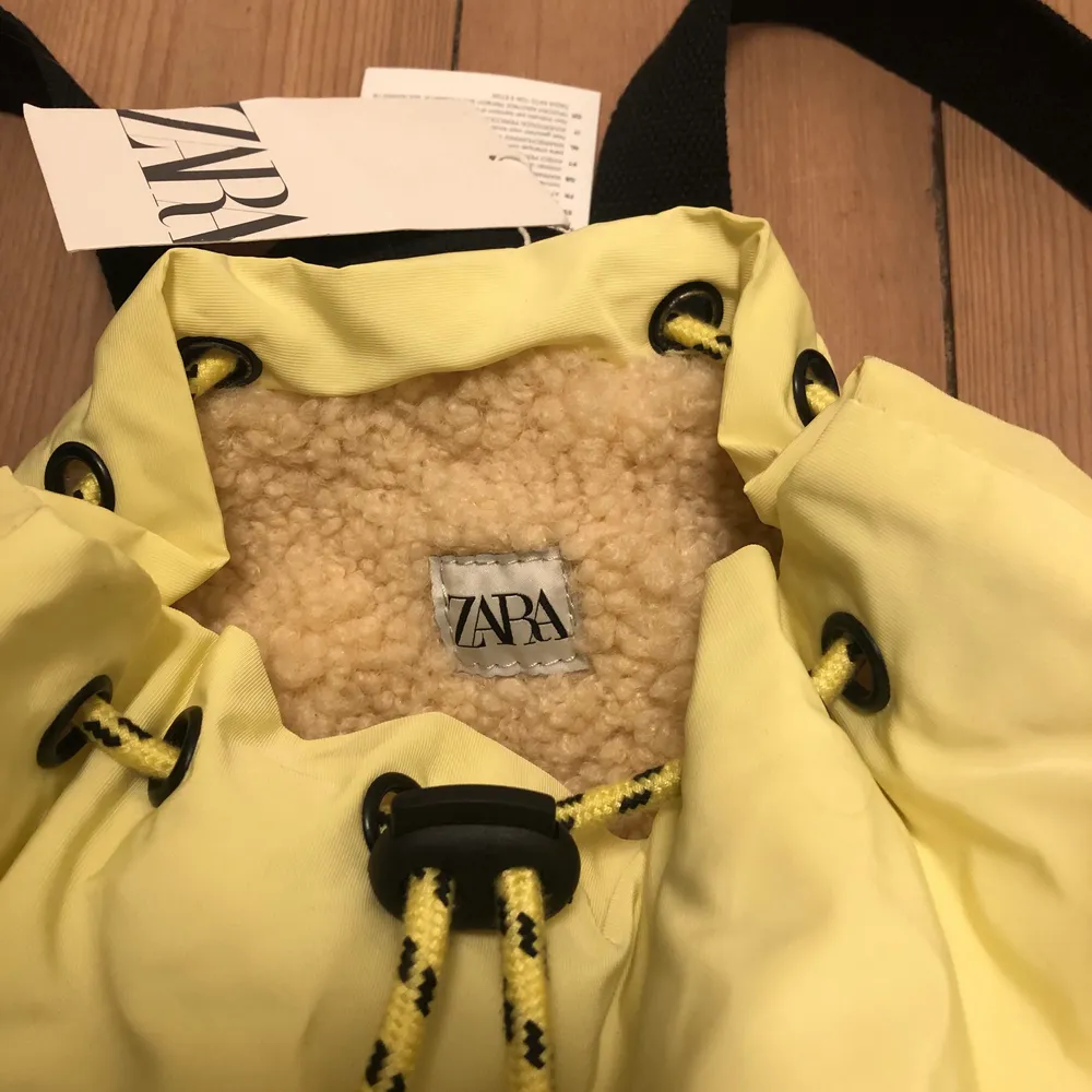 Cool gul ryggsäck från Zara! Den är helt oanvänd och har lappen kvar. Snygga detaljer som fickor i fuskpäls. . Väskor.