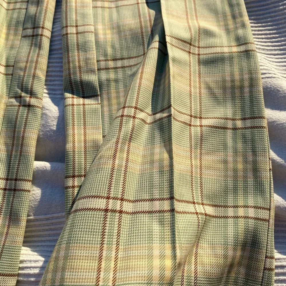 Ett par gröna rutiga byxor, med bruna, vita och gula detaljer. Extremt fina men aldrig använda.  . Jeans & Byxor.