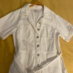 Topshop jumpsuit playsuit storlek UK12 M - En vit jumpsuit från topshop limited edition kan inte köpa längre. Perfekt för sommaren. Har haft på mig den några gånger men är i jätte bra skick. Bra kvalitet på jeans material. Storlek UK 12 men skulle passa S 