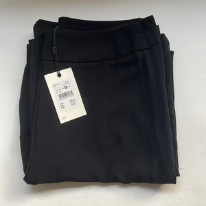 Kostymbyxor  - Högmidjade oanvända konstymbyxor från bikbok i storlek 40