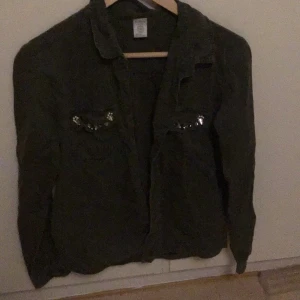 Lindex mörkgrön jacka - Mörk grön jacka med fake diamant detaljer på bröstfickorna