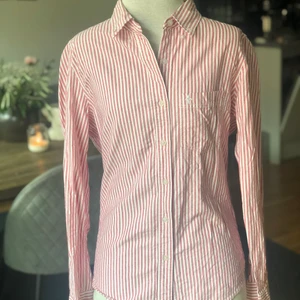 Randig rosa/röd skjorta - Långärmad, röd-/rosa-/vitrandig från Lager 157, sparsamt använd. Storlek S.   Mått på docka  Byst: 76  Midja: 65 cm Stuss: 96 cm  För fler bilder eller frågor kring frakt är det bara att skicka iväg ett PM! 📦📸