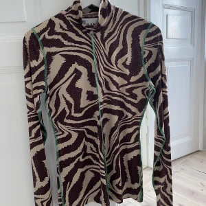 Ganni topp storlek 36 - Ganni topp med polokrage. Leopardmönstrad med gröna sömmar och paljetter. Fint skick