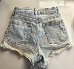 Jeansshorts H&M - KLICKA KNTE PÅ KÖP NU!Säljer dessa jeansshortsen från HM så de blivit för små. Har haft de ett tag så har använt de en del men de är i bra skick. Har blivit lite solblekta men det är ändå en fin färg på de. Midjemått:30cm tvärs över. Säljer för 100+frakt.