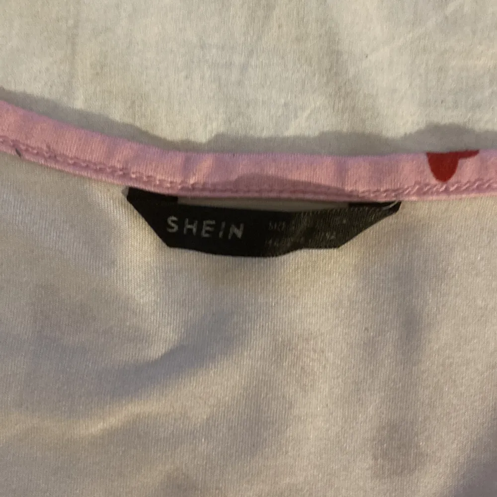 Rosa crop top med knappar och hjärtan på storlek S/M från SHEIN stretchig. T-shirts.