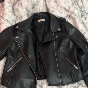 Skinnjacka - Säljer denna skinnjacka i storlek 42 dock är den väldigt liten i storleken, Ifall du bär 36 så kommer den sitta fint med en lite tjockare tröja under.  Jackan har två små vita fläckar på högra ärmen men det är inget man märker av. 