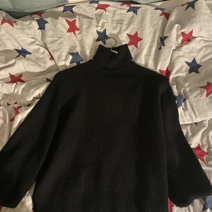 Svart stickad tröja från Zara med trekvartsärm - Svart stickad tröja från Zara, knappt använd. ”Invikta ärmar. Jätteskön säljer bara då jag måste rensa kläder. Storlek S. Den är stockholmstil, säljs inte på Zara längre 