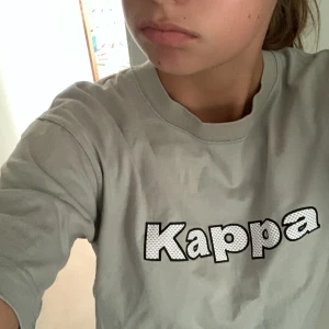 Overzised Kappa t-shirt - Tröjan köptes i början av sommaren och har använts sparsamt (inga defekter) den är i mansstorlek M men passar perfekt på mig som är S.(Den är beige)❤️❤️