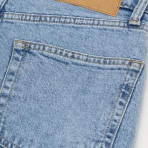 Otroligt snygga ankellånga jeans i tvättad denim. Lösare passform med något avsmalnande ben.  Hög midja.  Knappgylf.  Unisex-modell.   Märke: Divided från H&M.  Storlek: 34