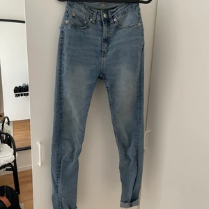 Blåa jeans  - Blåa höga och tighta jeans, stora i modellen. 