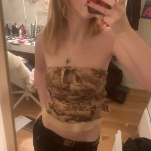 Topp - En jättesöt topp med beige brunt mönster och många fina detaljer.