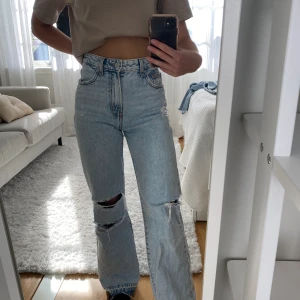 Raka jeans med slitningar - Raka jeans med slitningar från Bershka! Använda ganska många gånger med är fortfarande i mycket bra skick. Strl 34, jag är 170 cm lång.