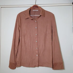 Brun skjortblus - En brun skjorta i speciellt material, känns lite som väldigt tunn mocka (är inte). Ingen storleksmärkning men är som en M🌿