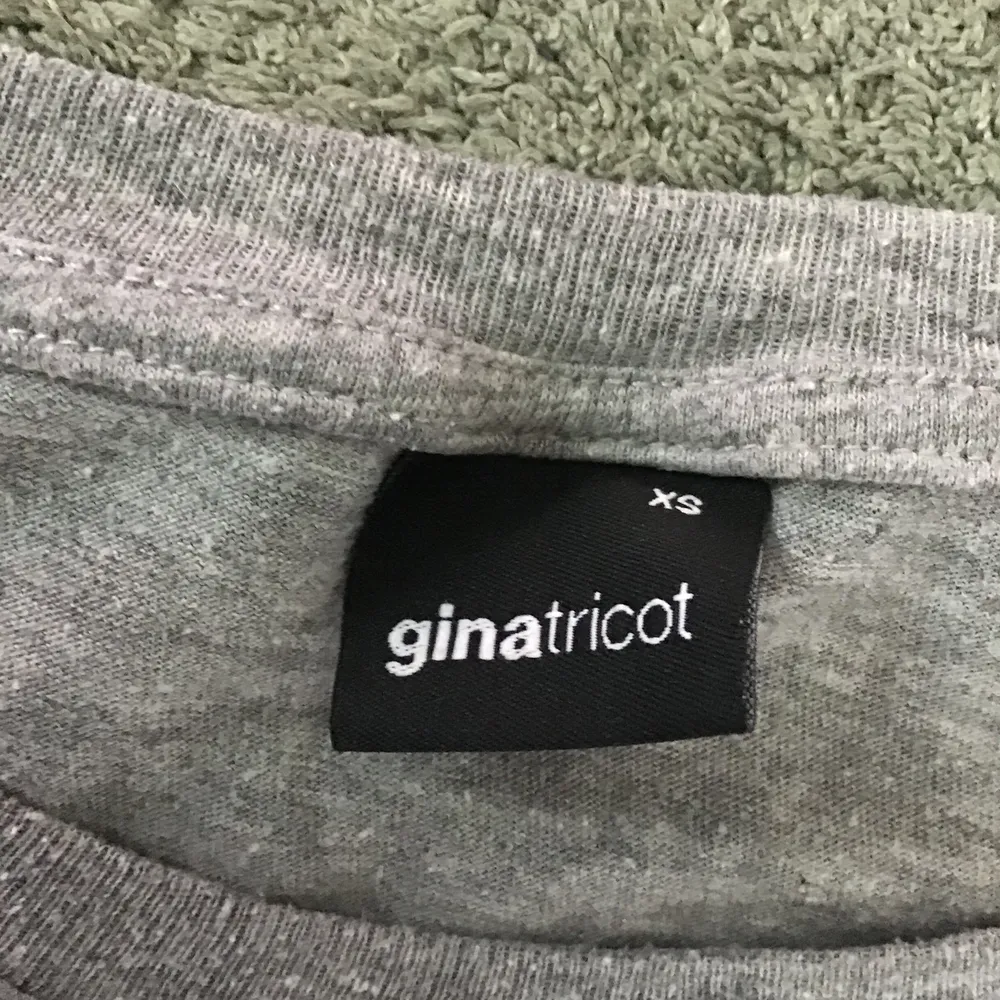 En grå  t-shirt med tryck jag köpte på Ginatricot! Knappt använd ❤️. T-shirts.