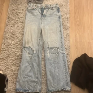 Jeans  - Fina blå jeans från Gina. Två hål på knäna som en fin detalj. Storlek 38, kan passa 40 oxå skulle jag tro. Köparen står för frakten! 