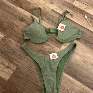 Grön glitter bikini - Säljer denna glitter bikini från bikbok i storlek Xs i trosorna och S i överdelen 50kr ihop eller 30kr styck. Endast testad