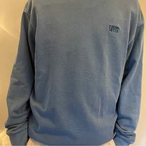 En blå sweatshirt från Levi’s som inte kommer gilla nvändning. Det är i bra skick