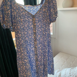 Sommarklänning - Super fin blå sommarklänning med blommor köpt på mango, funkar lika bra att knyta i fram som i bak eller att inte knyta alls. Säljer då den tyvärr inte kommit till användning och har andra liknande.🤍💐🌻🌼🍋