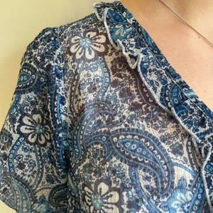 Blus strl 40 - Plagget är i genomskinligt tyg, knappar längst fram samt ett band som även går att knyta! 