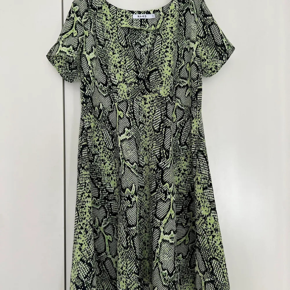 Grön klänning med ormskinns print. Går till strax över knäna. Aldrig använd.. Klänningar.