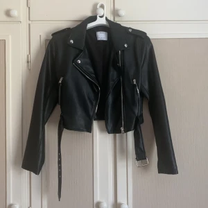 Skinnjacka  - Säljer denna fina skinnjacka (som snarare är en M) då den inte kommer till användning. Använd 2-3 gånger så i perfekt skick med silver detaljer och fungerande fickor. I läderimitation men verkligen super fin och perfekt till vår och sommar! Nypris: 299kr