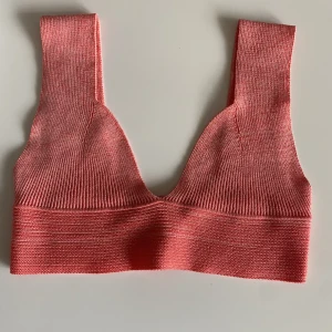 Korallrosa topp - En superfin somrig topp som är stretchig med ett ribbat mönster! 