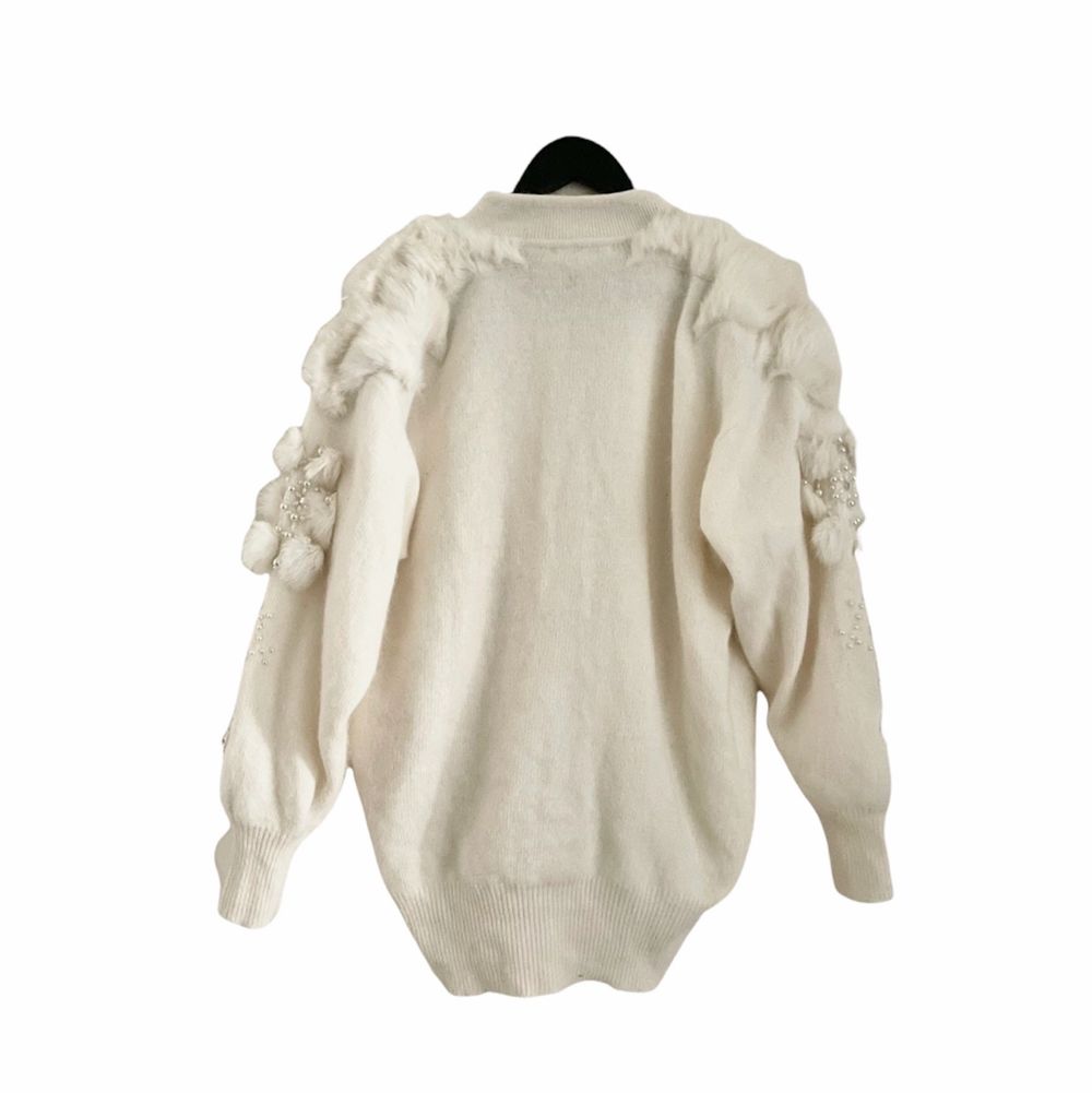 Absolutely stunning rare find that keeps your soft cozy warm and chic, this vintage 80s wool and angora cardigan is an absolute dream. It’s decorated with multiple faux pearls, rhinestones, and fox fur pompoms, worn buttoned front closure and balloon sleeves. Excellent vintage condition. One size, oversize fit. Measurements Length 74cm Shoulders 53cm Sleeves 55,5cm Chest 61cm. Tröjor & Koftor.