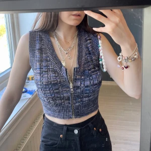 Stickad väst - Stickad väst i mönstrat lila, funkar att ha själv men också med något under. Köpt på Asos för ca 1 år sen. Dragkedja framtill, väldigt stretchigt material. Är tyvärr lite stor för mig, jag bär normalt storlek 32/XXS och är 166cm lång. 