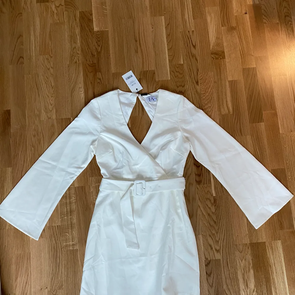 Fin vit klänning från Linn Ahlborg x NA-KD. Köpt för 2 år sedan men aldrig använd, prislapp kvar. Öppen i ryggen. Perfekt som studentklänning 🌸. Klänningar.
