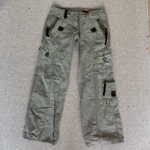 Cargopants - Cargopants. Dom är antingen missfärgade på ett ställe eller så är designen så. Men om man zoomar in på andra bilden så kan man se det på vänster knä ungeför. Finns en dragsko i midjan så man kan dra åt