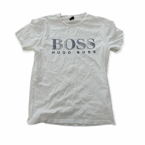 Vit Hugo Boss T-shirt strl M - Säljer min vita Hugo Boss T-shirt som är i storlek M. Tröjan är cirka ett år gammal men är i bra skick. Frakt tillkommer. Skriv för mer info.