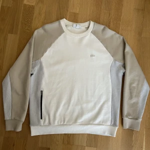 Lacoste Colourblock Sweatshirt - Sparsamt använd tröja från Lacoste i storlek L. Slutsåld i Sverige. Tröjan är fri från slitage och fläckar. 
