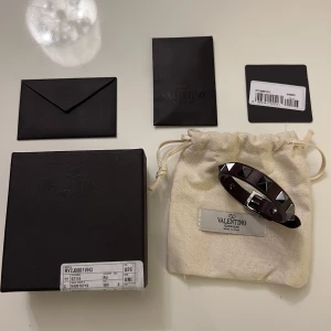 Valentino armband - Säljer nu mitt sjukt snygga och trendiga valentino armband i mörk röd färg med silvernitar. Denna färg är en favorit hos många och även mig. 10/10 skick då det är HELT NYTT. Det medföljer även låda, extranitar, dustbag samt äkthetsintyg. Pris: 1399 sek